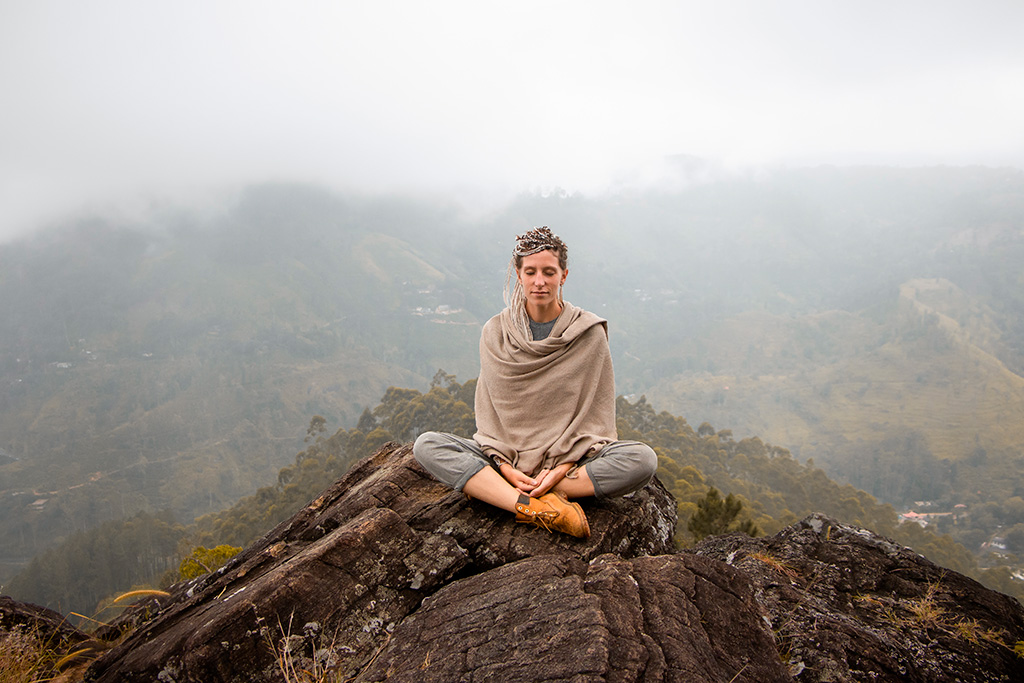 Frau, meditierend am Berg